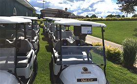 Rows of white golf carts parked on the grass