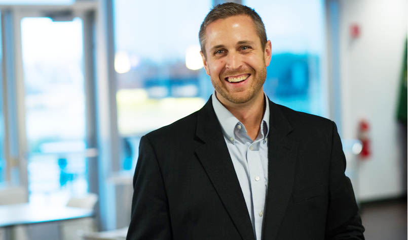 Profile photo of a man in a black blazer smiling