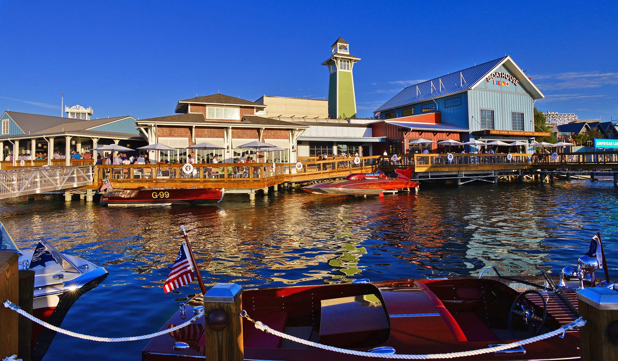 Daytime exterior shot of a vintage boathouse with a pier and boats parked alongside