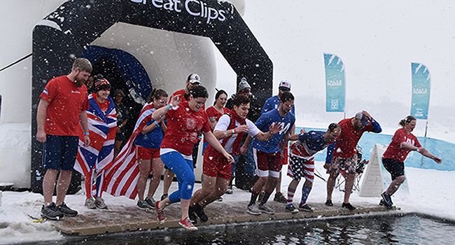 A group of employees leaping into frigid cold water at a Plar Plunge event