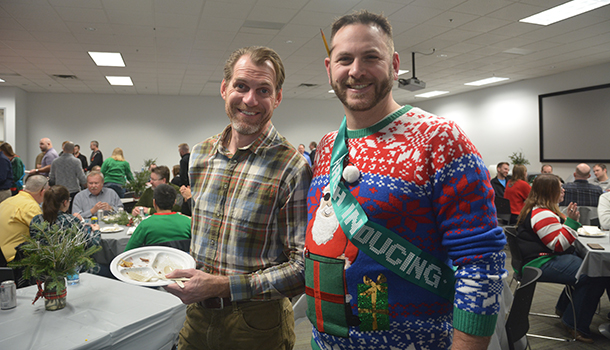 Two VAA employees smiling for the camera in ugly holiday sweaters