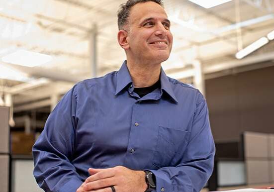 Candid photo of a man in a blue dress shirt smiling